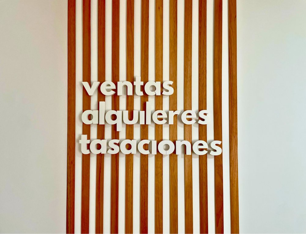 Cartel de ventas, alquileres y tasaciones en la oficina de Flat Propiedades